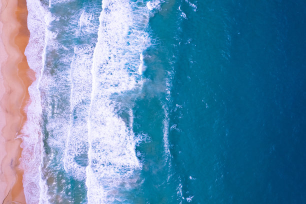 夏季海滩海和海浪撞击沙滩的鸟瞰图，令人惊叹的海滩与海浪泡沫，美丽的海面的美丽俯视图，概念假期夏季背景图片下载