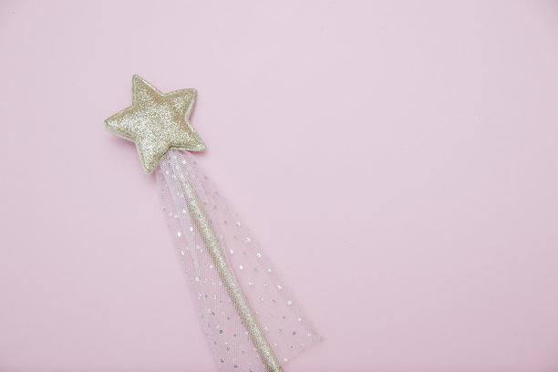 魔术棒，节日装饰，明亮的银星闪耀在柔软的粉红色背景与复制空间。横幅网站。最小的假期概念。图片下载