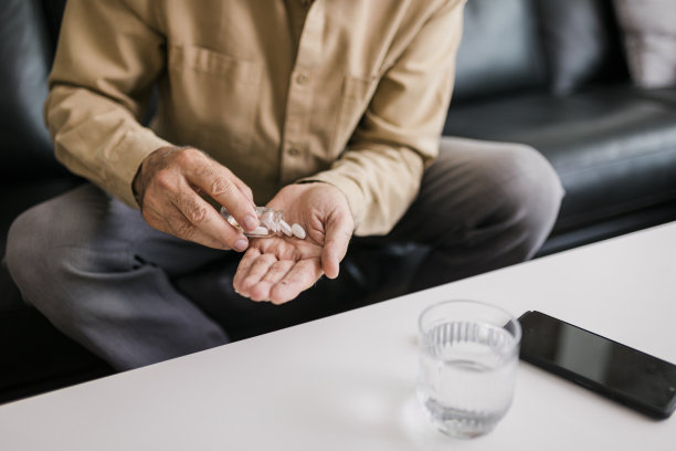 老年男子服用每日剂量药物的特写图片下载