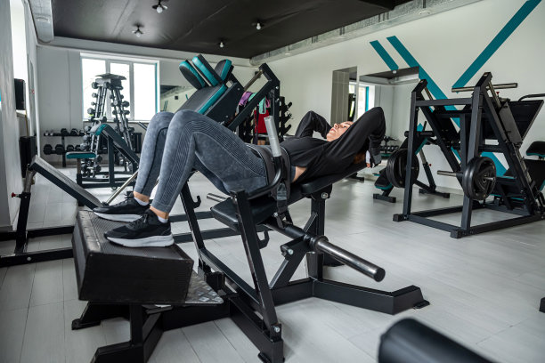 年轻迷人的健身模特正在健身器材上做腹肌练习。图片下载