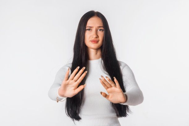 阻止它。年轻女子站在白色背景下，看着镜头，用手做“不”的手势。严肃的长发女孩不赞成史密斯、禁止、忌讳手势图片下载