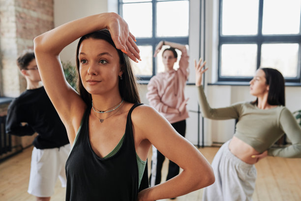 穿着运动服的少女在舞蹈训练时把胳膊放在头上图片下载