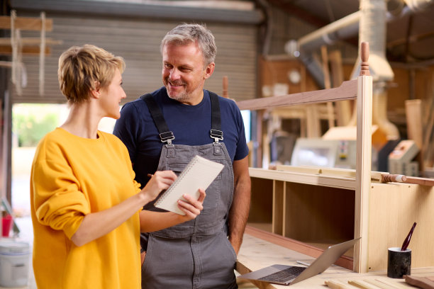 女学徒在家具车间向成熟男木匠学习技能图片下载