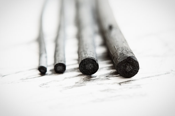 一组不同大小的天然木炭铅笔停在素描纸上的特写图片下载
