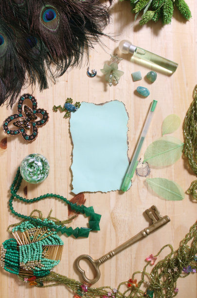 复古烧纸和古董钥匙周围的绿色珠宝和孔雀羽毛图片下载