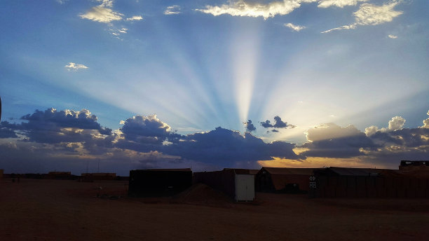 风景如画的照片，太阳光线在厚厚的云层后面在田野上图片下载
