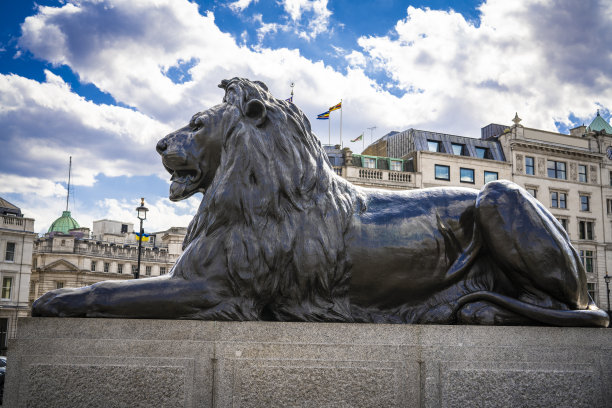 狮子雕像在伦敦特拉法加广场在一个晴朗的夏天蓝天的日子。名字:Landseer Lions图片下载