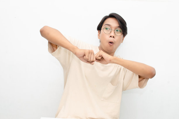 亚裔男子在白色背景下快乐地跳舞，用“是”的手势庆祝好消息。人，欢乐，乐趣，幸福理念。庆祝派对概念图片下载