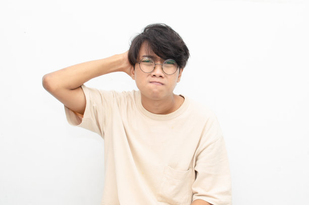 那个亚洲男人看起来很沮丧，很混乱。一个愤怒的人咬着嘴唇，挠着头。强调工作理念。图片下载