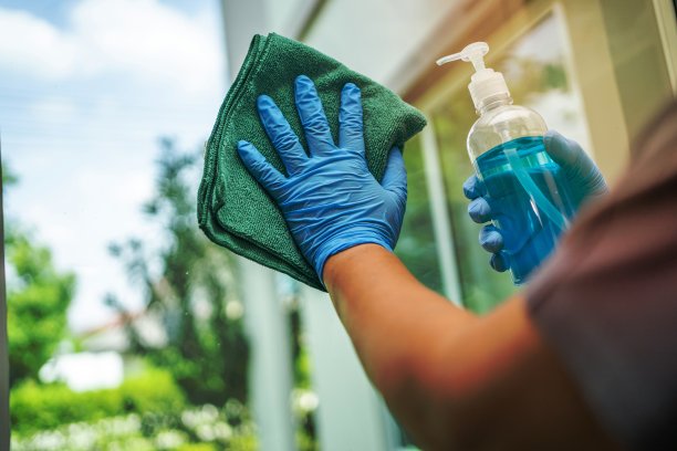 女佣清洁擦拭和清洗寡妇在家里的玻璃。图片下载