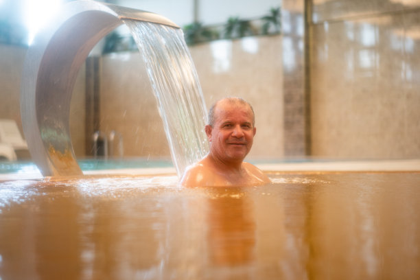 一名男子享受着热水的喷射图片下载