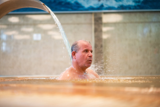 一名男子享受着热水的喷射图片下载