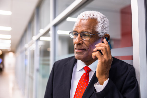 一个老年黑人商人使用智能手机的肖像图片下载