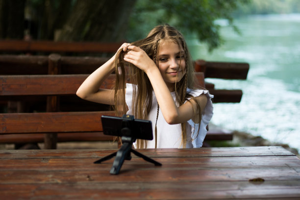 快乐的年轻女孩拍摄发型vlog图片下载