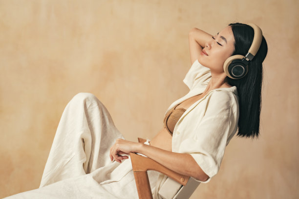 亚洲女性在紧张的一天工作后休息，戴着耳机听着平静的冥想音乐图片下载