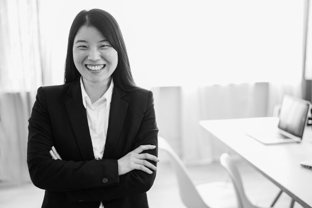 亚洲年轻女子在现代办公室内对着镜头微笑图片下载