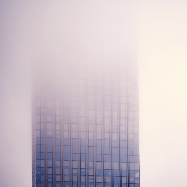 摩天大楼的窗户在雾中，背景复制空间。烟雾中的高层建筑的金属结构和窗户，特写图片下载