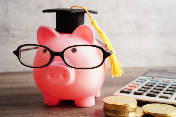 小猪银行戴眼镜用硬币和计算器储蓄银行教育理念。图片下载