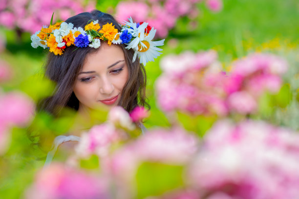 童话形象艺术照片。户外特写年轻美丽快乐微笑幻想女人的肖像。年轻的女神在明媚的阳光和粉红色的玫瑰中享受着春天的自然图片下载