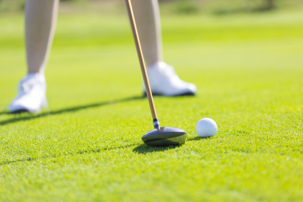 近距离的高尔夫设备，一个高尔夫球手练习高尔夫在阳光明媚的日光高尔夫球场的绿色-股票照片图片下载