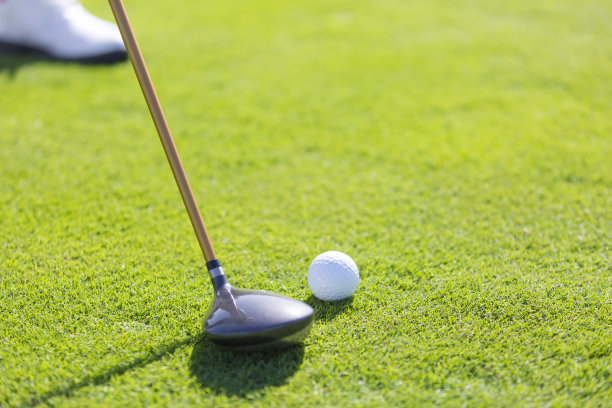 近距离的高尔夫设备，一个高尔夫球手练习高尔夫在阳光明媚的日光高尔夫球场的绿色-股票照片图片下载
