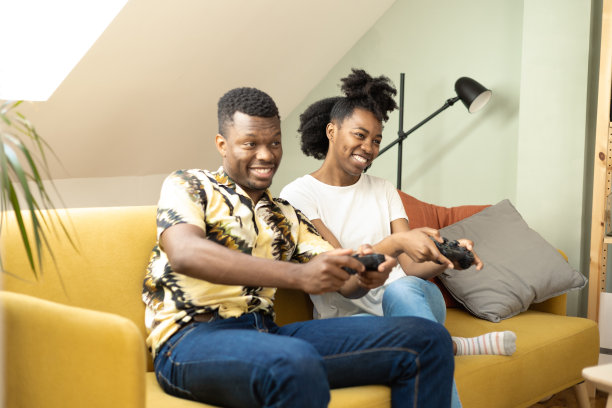 一对非裔美国夫妇在家里玩游戏图片下载