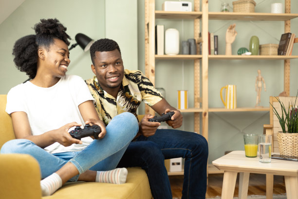 一对非裔美国夫妇在家里玩游戏图片下载