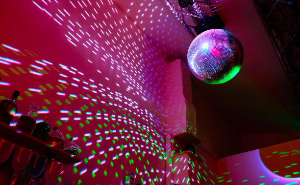 迪斯科球在黑暗的大厅里反射出淡紫色的光。图片下载