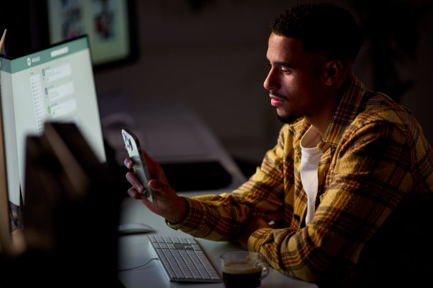 商人在办公室工作到很晚，面部被手机屏幕照亮图片下载