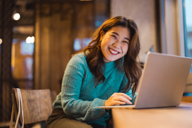 年轻女子在咖啡店用笔记本电脑工作图片下载