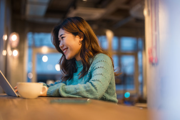 年轻女子在咖啡店用笔记本电脑工作图片下载