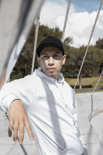 男子头戴白色帽子和连帽衫，穿着舒适而运动的衣服，生活方式自然优美图片下载