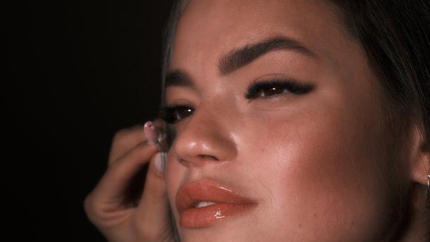 化妆师在拍摄前调整模特的睫毛图片下载