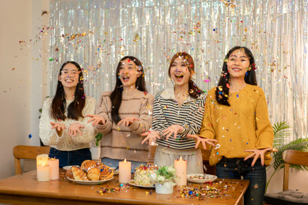 年轻漂亮的女人玩和拉彩纸派对享受在家里庆祝新年派对图片下载