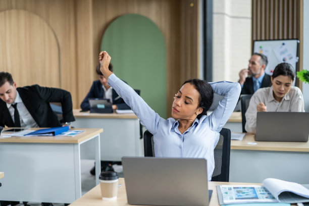 一群在办公室工作的年轻商人。有魅力的员工坐在桌子上，感到快乐和放松计划项目在工作场所。现代企业同仁的观念。图片下载