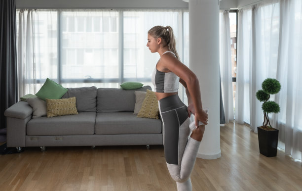 年轻女子在车祸事故后在家进行康复锻炼。恢复锻炼的年轻女孩与瑜伽冥想训练姿势伸展肌肉。女性产后放松。图片下载