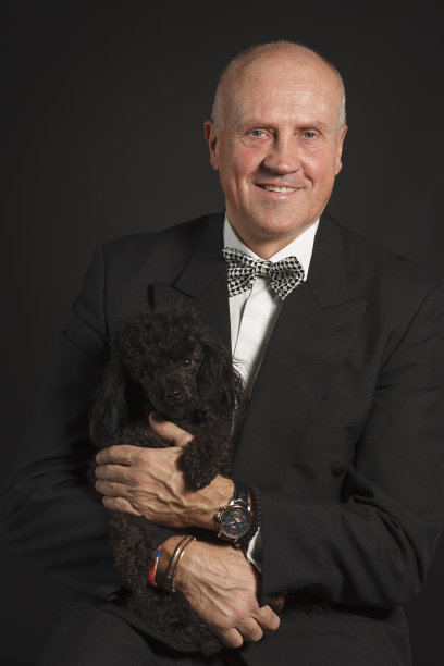 宠物的爱。一个老男人的肖像与狗，黑色迷你狮子狗。友谊，黑白背景。图片下载