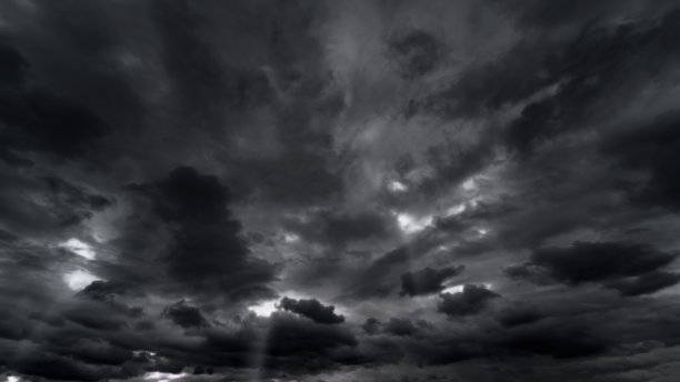 黑色戏剧性的天空，雨雪前的黑色暴风雨云作为抽象背景，极端天气，太阳透过云层，高对比度照片图片下载