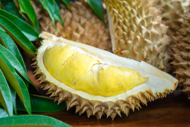 榴莲熟了又鲜，榴莲皮黄了放在木桌上。图片下载