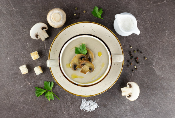 蘑菇奶油汤，配料:香槟酒，面包丁，奶油，香料和欧芹。棕色的背景。前视图。图片下载