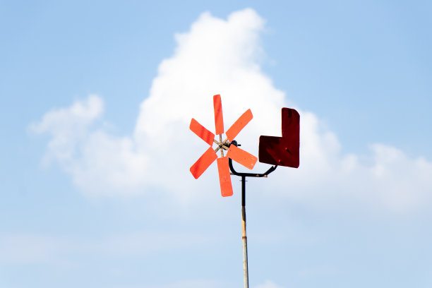 蓝色天空背景上的红色风车图片下载