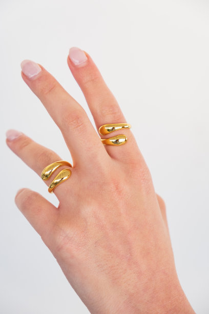 女人的手与大胆的可调金戒指设置在白色背景。图片下载