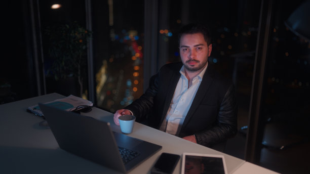 年轻的商人在办公室工作到深夜的肖像图片下载