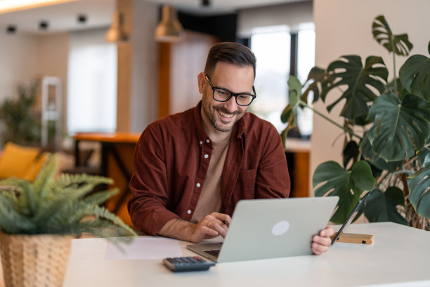 微笑的自由职业者在家里工作图片下载