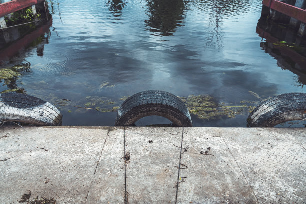 在一个小港口里，有三个旧汽车轮胎作防撞用图片下载