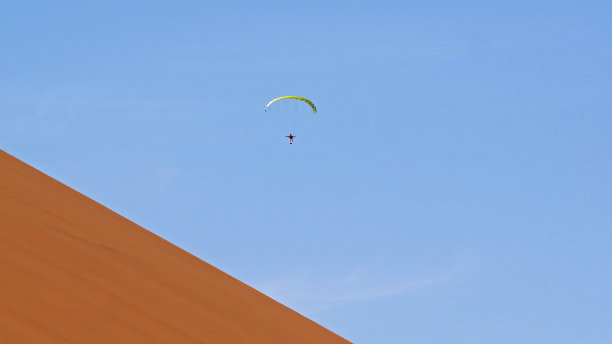 滑翔伞飞过纳米比亚的沙丘图片下载