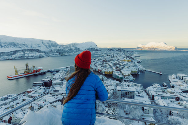 在挪威，一个女人在雪地上凝视着奥勒松市的背影图片下载