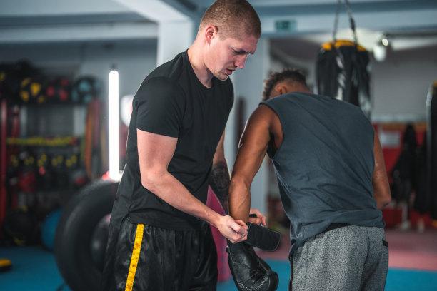 中年成年黑人男子准备与拳击教练在健身房图片下载