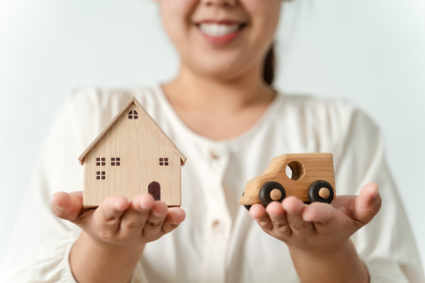 困惑的亚洲女性买家在买新房还是买车之间做出选择。图片下载