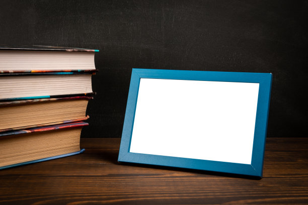 木桌上有一堆书和一个相框。本空间图片下载